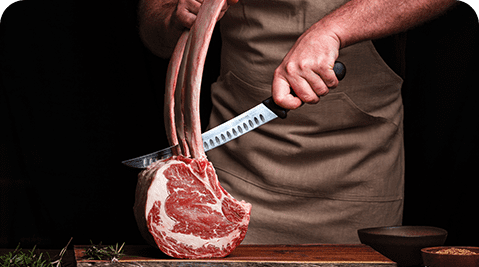 A person cutting meat with a knife