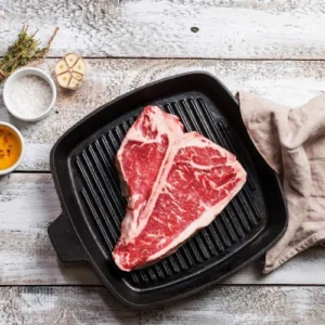 A steak is being cooked on the grill.