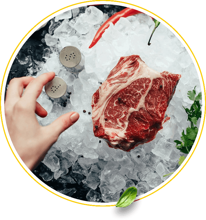 A person holding up a piece of meat on top of ice.